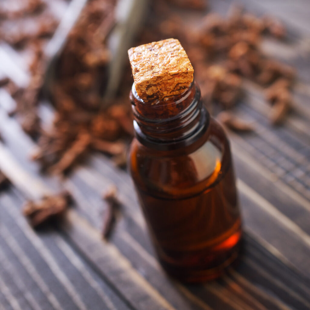 clove oil in glass bottles and on a table