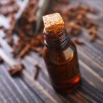clove oil in glass bottles and on a table